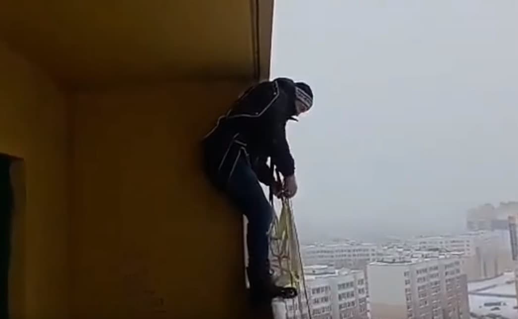 Yigit ko‘p qavatli uy balkonidan parashyutda sakradi (video)