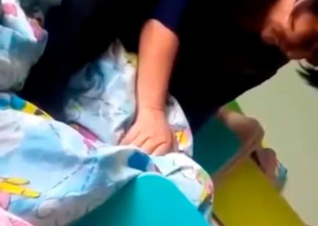 Video: Bog‘cha tarbiyachisi bolani uxlashga yotqizish uchun uni bo‘g‘di