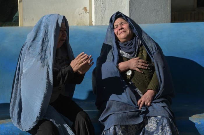 Afghan residents inspect the site of a suicide bombing outside a voter registration centre in Kabul on 22 April 2018